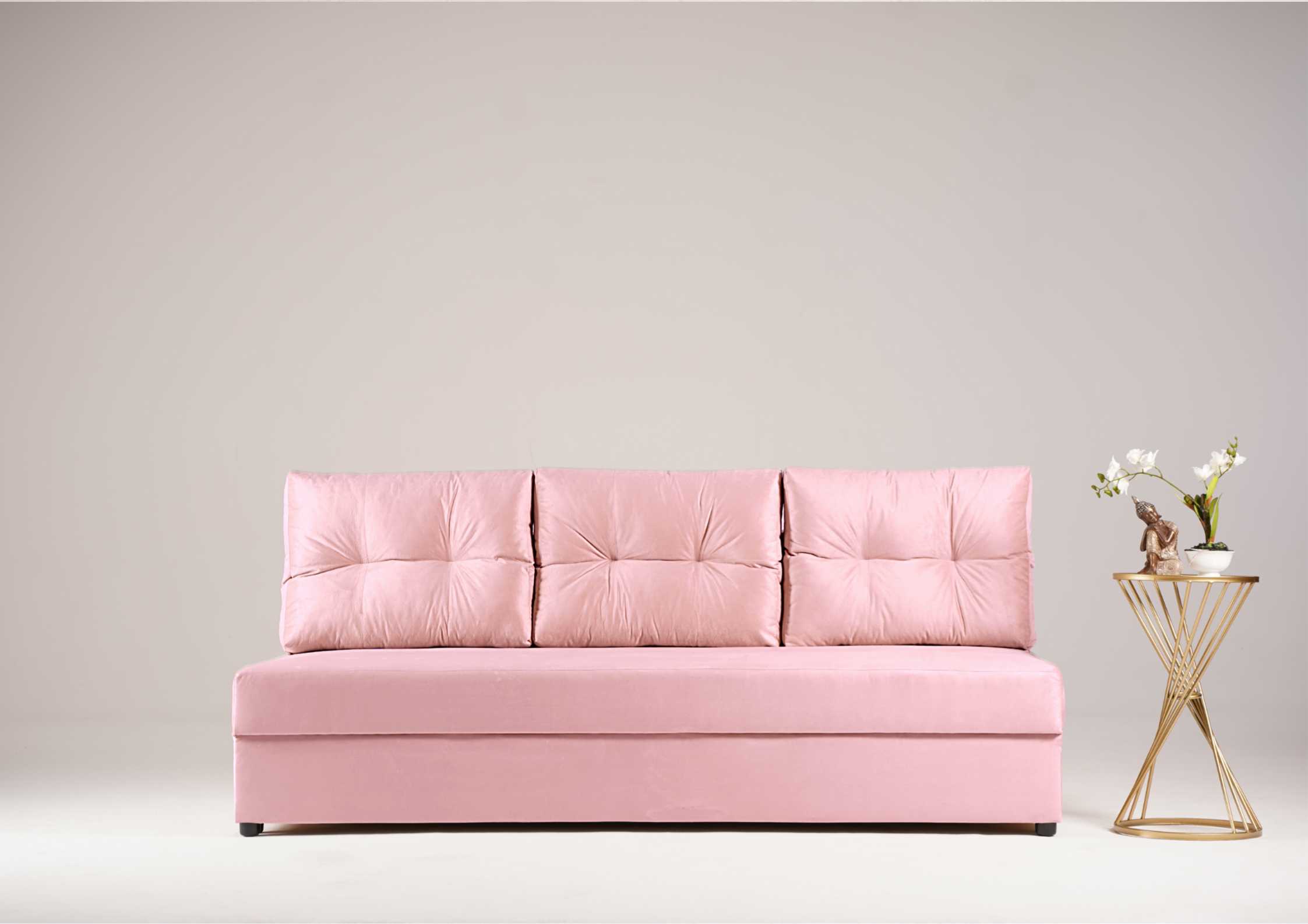 Różowa sofa z pikowanymi poduszkami